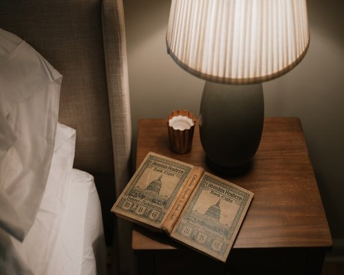 Soft light illuminating an open book on a nightstand for comfortable reading before sleep